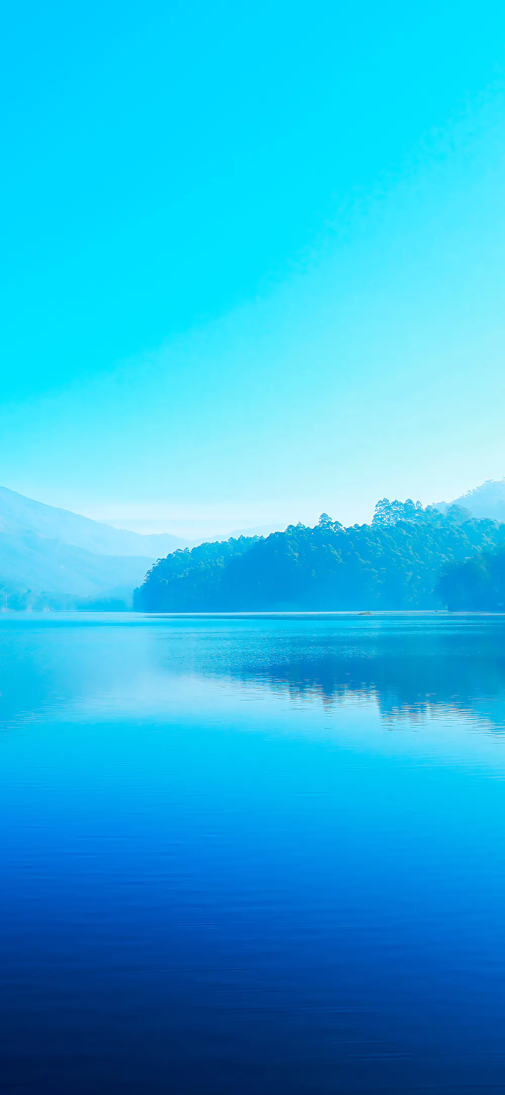 Serene Blue Lake with Misty Mountains and Soft Morning Light